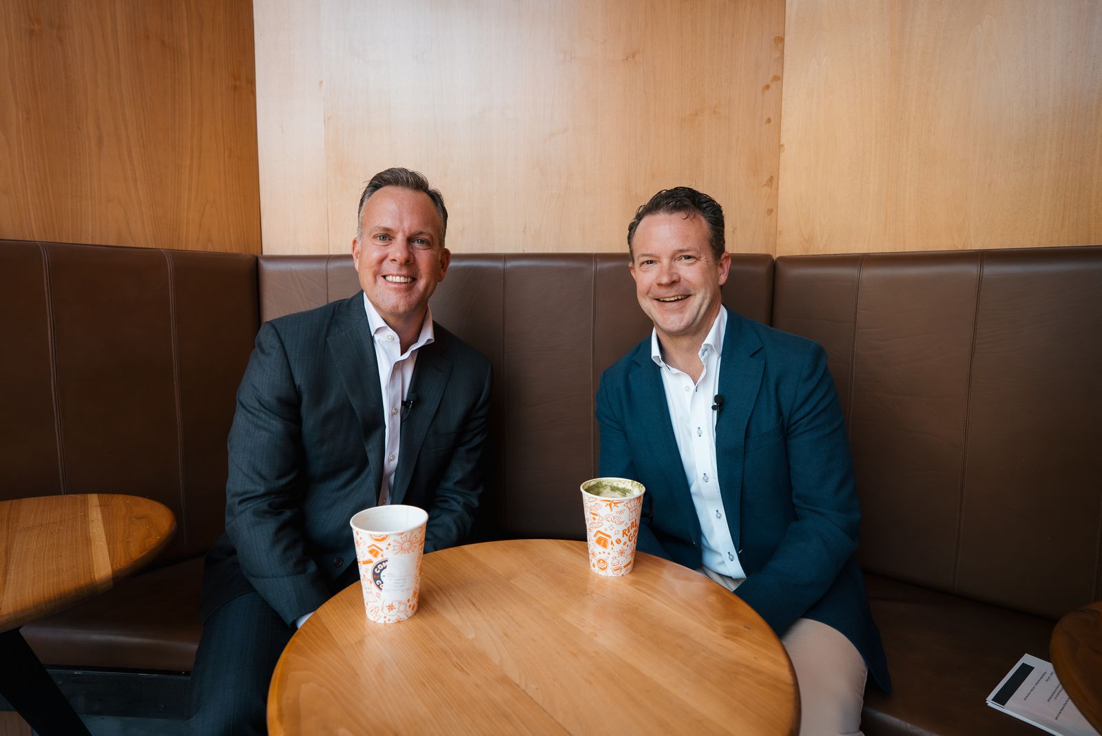 Two guests seated in the cafe booth before filming