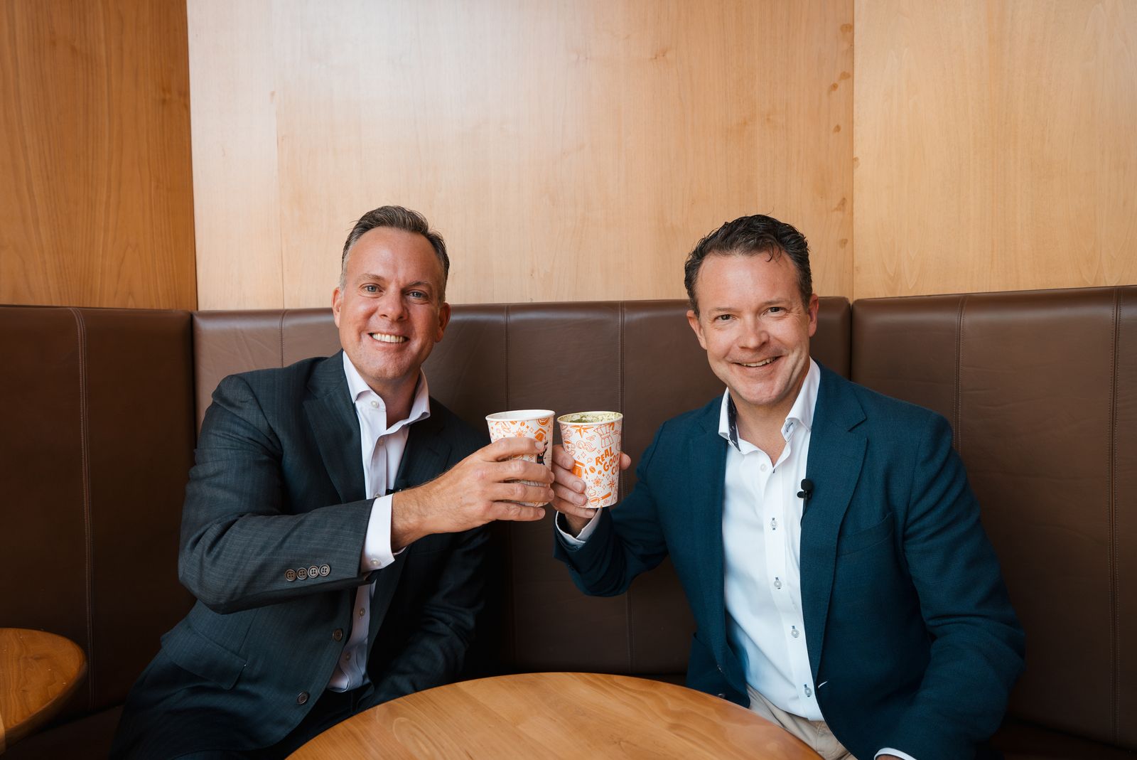 Dr. Nate Radcliffe toasting coffee cups with a guest