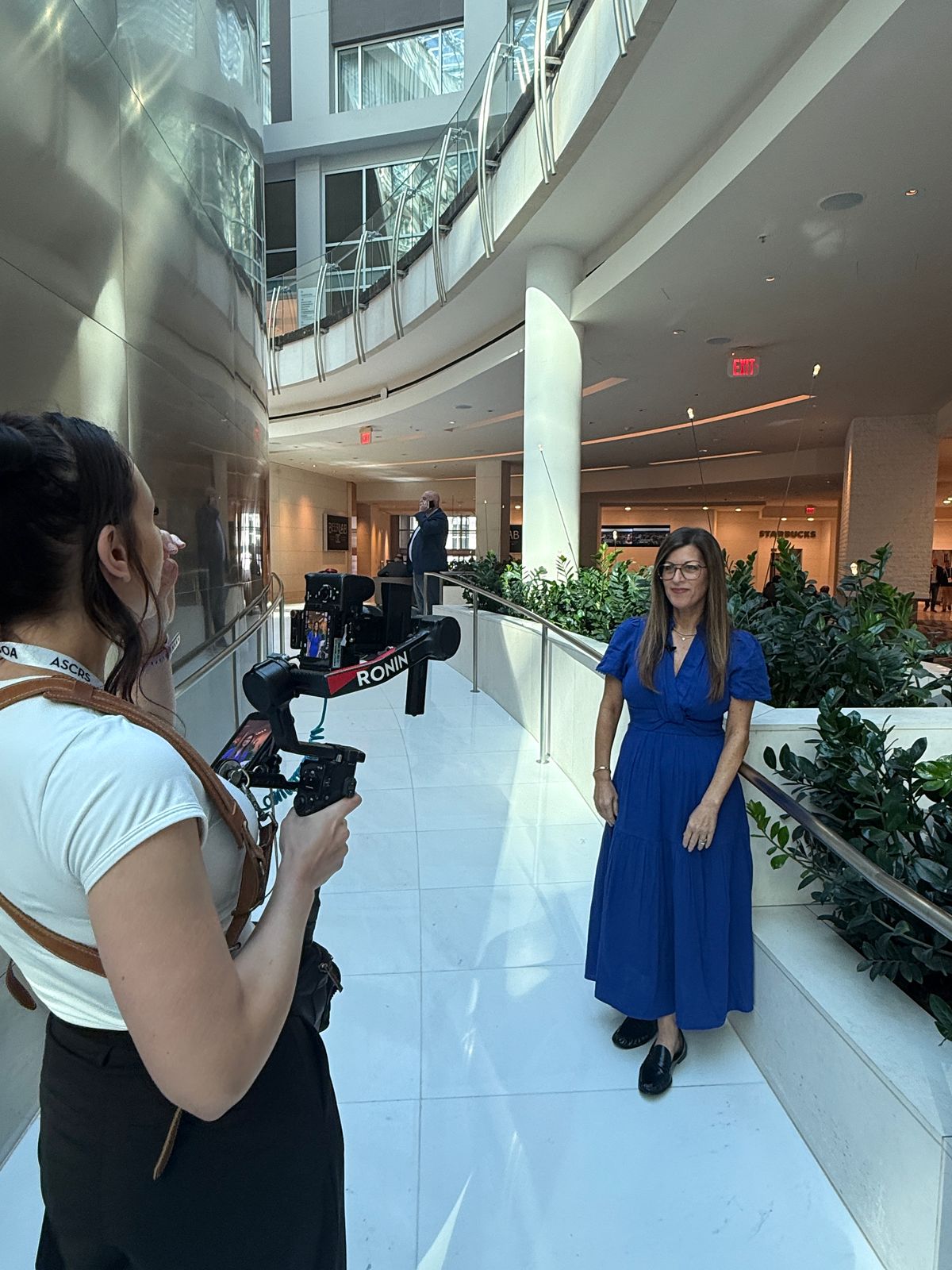 A physician being filmed at a conference with a gimbal-mounted camera